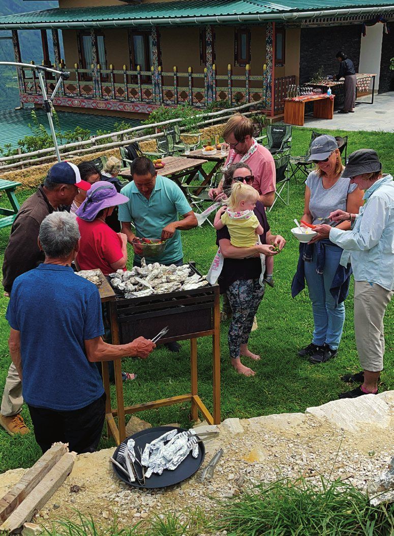 Guests at a farm barbecue on the lawn at The Happiness Farm