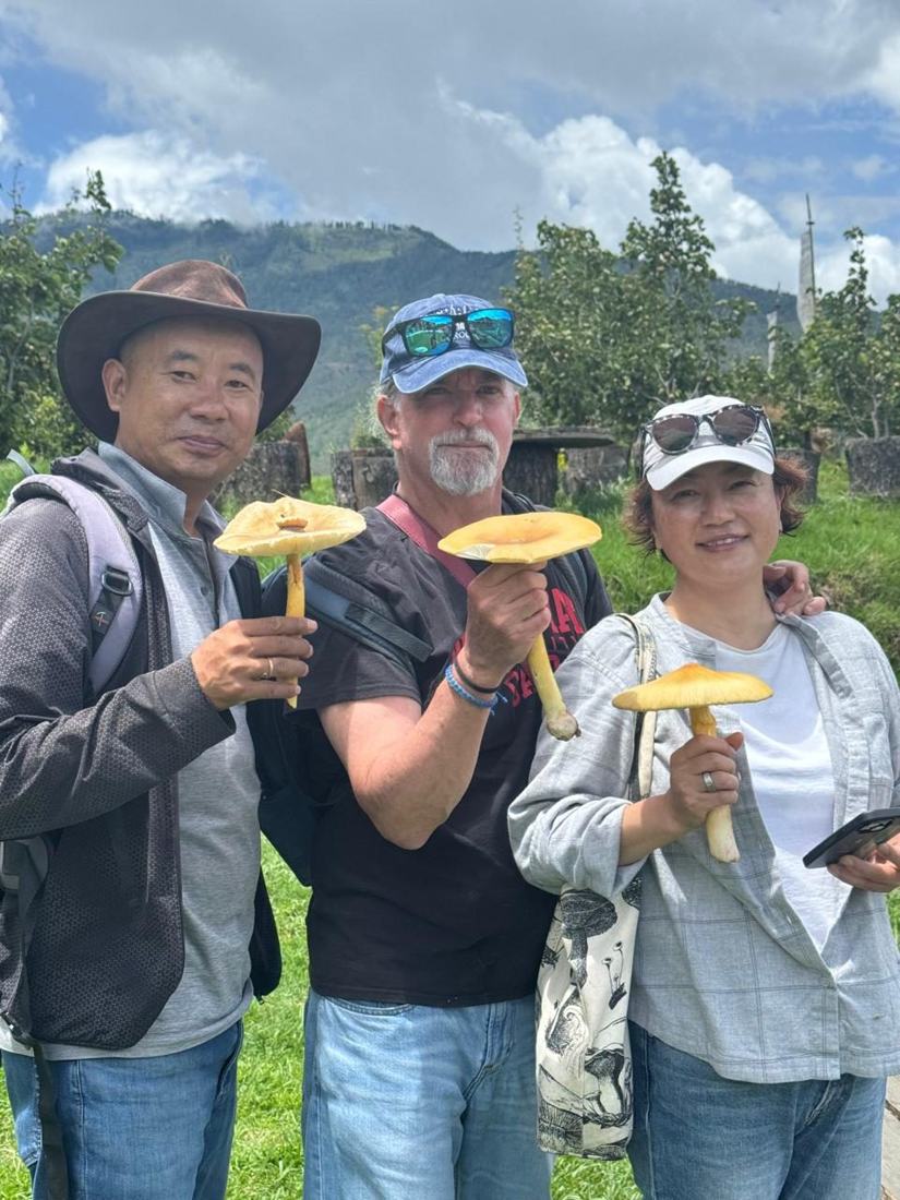 Michiko and James with Dorji holding wild mushrooms in Bhutan