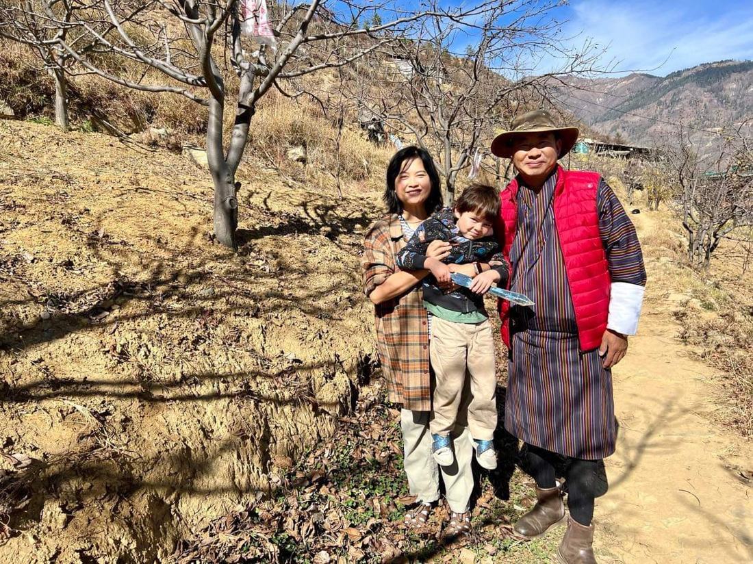 Nina You and her son with Dorji on a farm path at The Happiness Farm