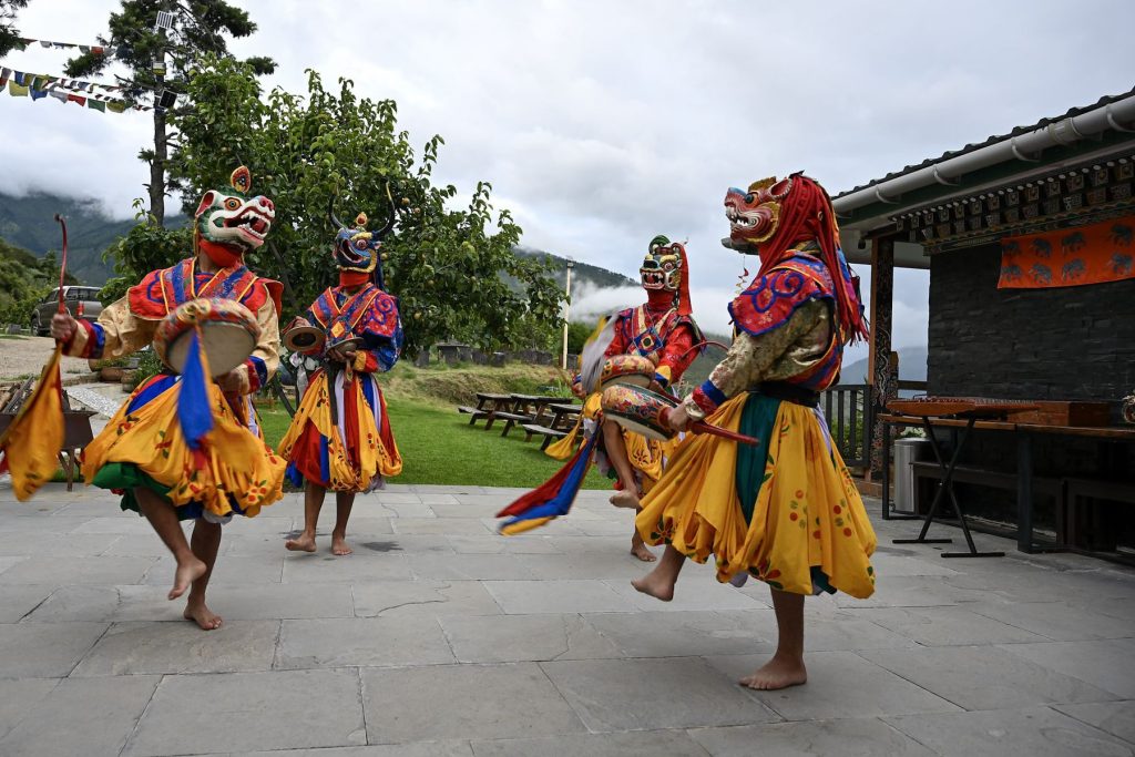 Masked dancers performing in the farm courtyard