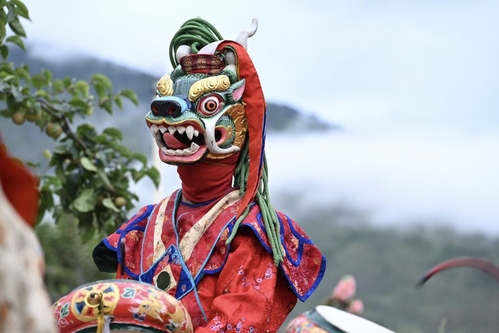 A masked dancer in a colourful costume