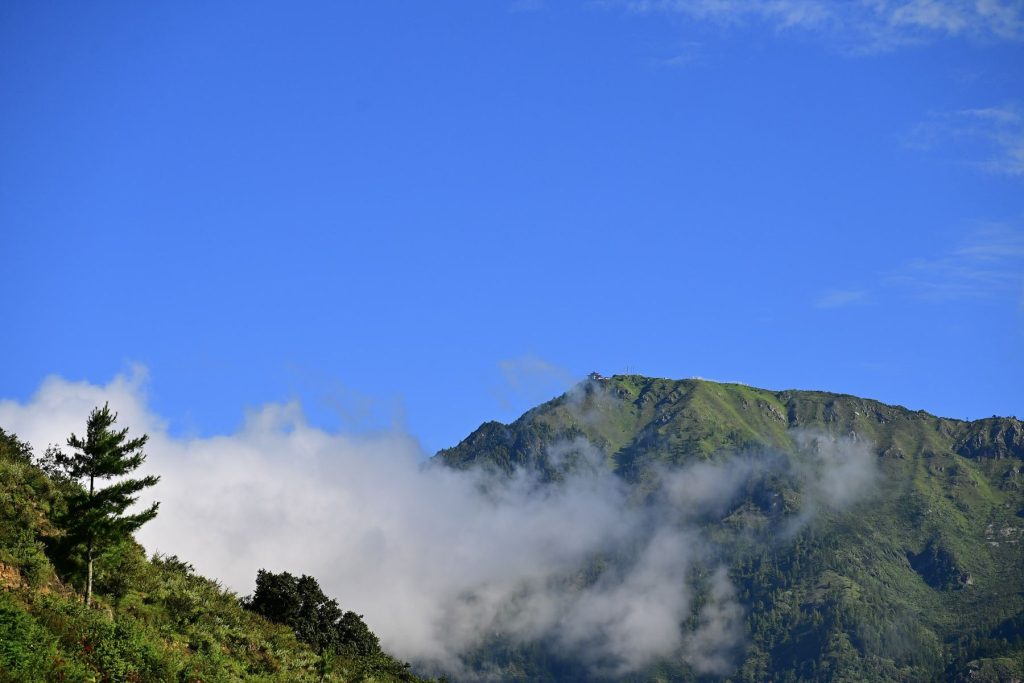 A mountain peak rising above the clouds near the farm