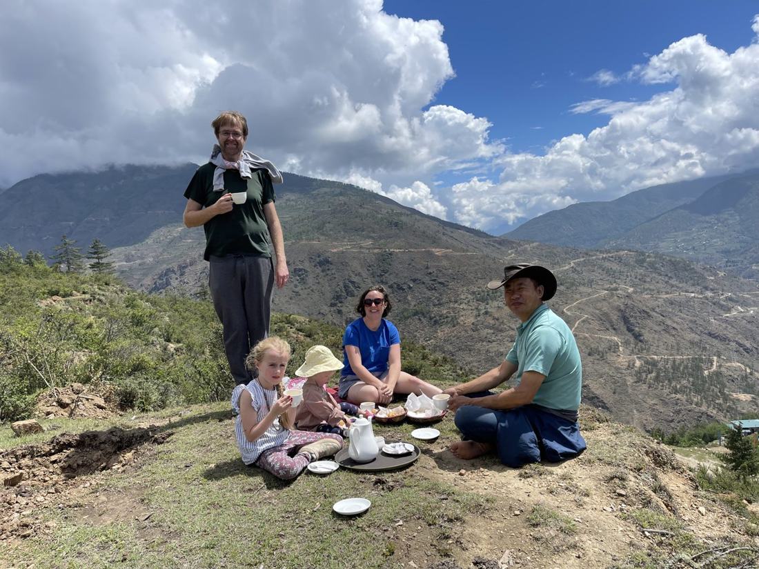Tim Wilson and Dr. Aoife Kennedy with their family at a hilltop picnic in Bhutan